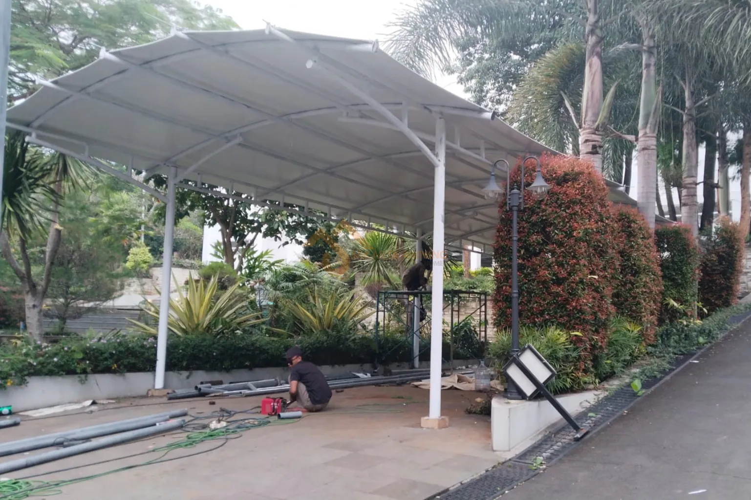 Pemasangan struktur kanopi membran berkualitas untuk area parkir kendaraan