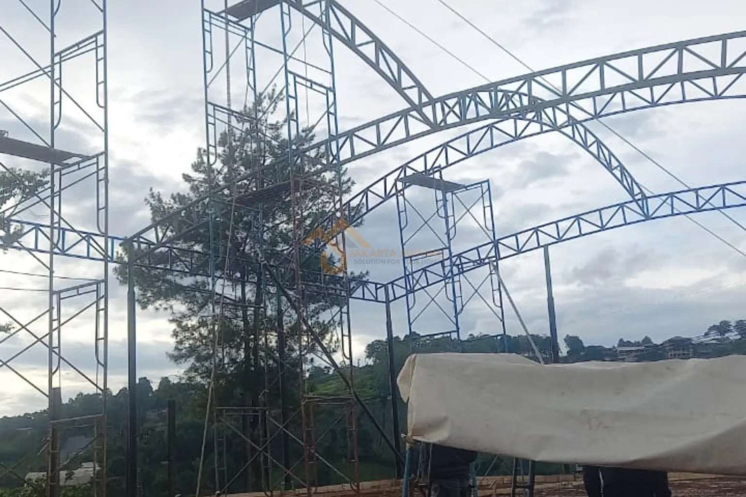 Kerangka pipa baja saling menyilang menahan beban tarik kain membran